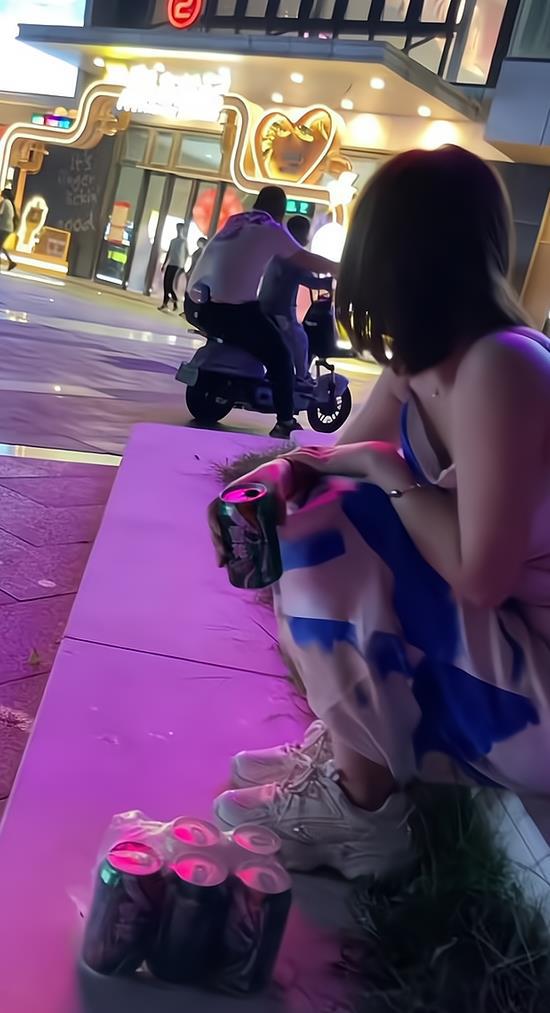 一女子找不到工作心情不愉快独自坐在马路边喝啤酒(图1)